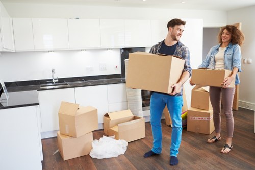 Specialist movers relocating a baby grand piano through a residential property